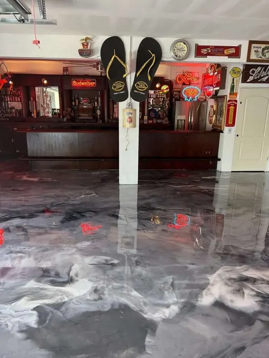 Gray marble-look metallic epoxy floor in a home bar and game room