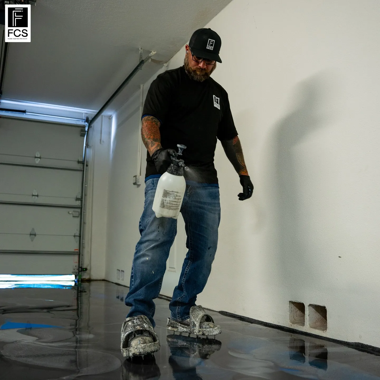 Installer misting a freshly poured metallic epoxy floor